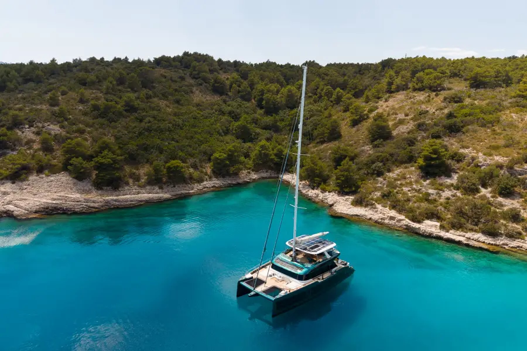 Midori at anchor in a quiet Mediterranean cove, seen from above