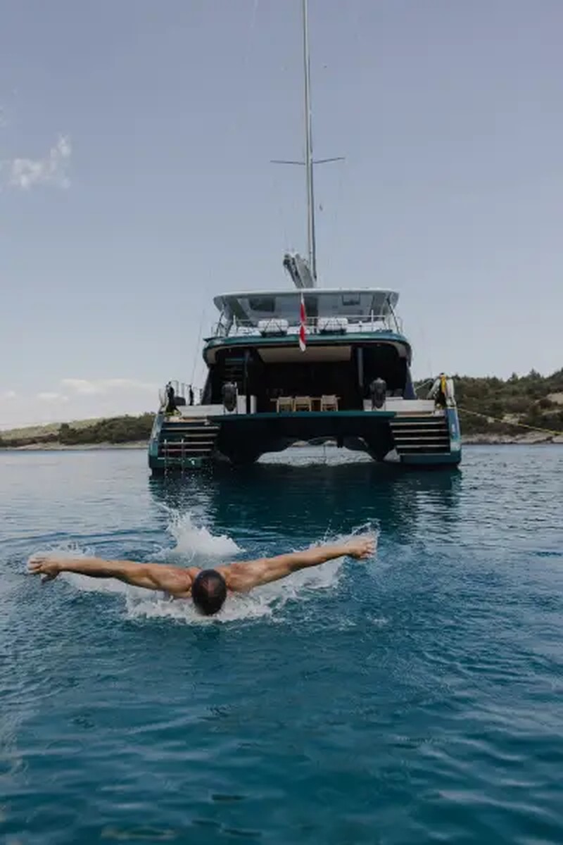 A swimmer gliding beneath the surface of clear blue Mediterranean water